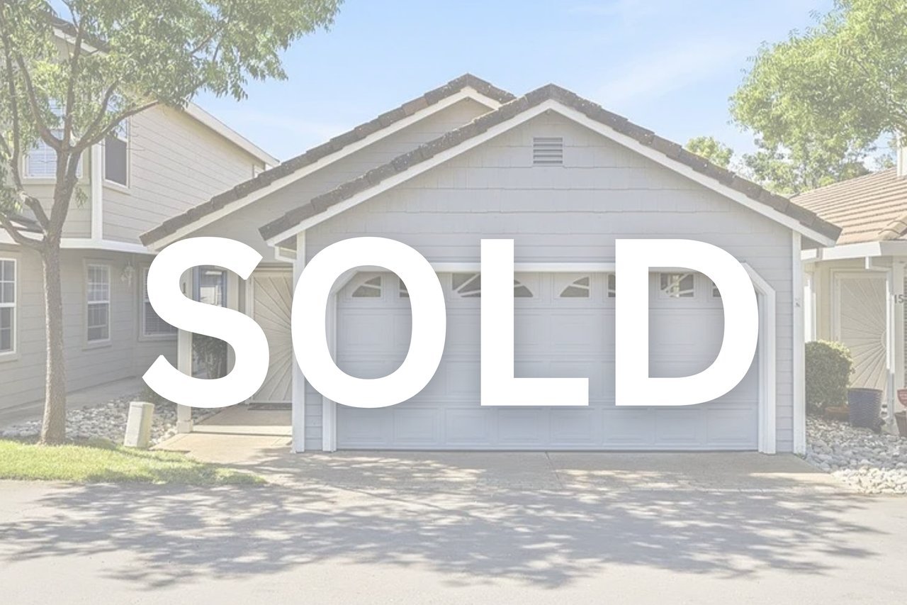 Light gray home with a two-car garage and driveway, marked SOLD.