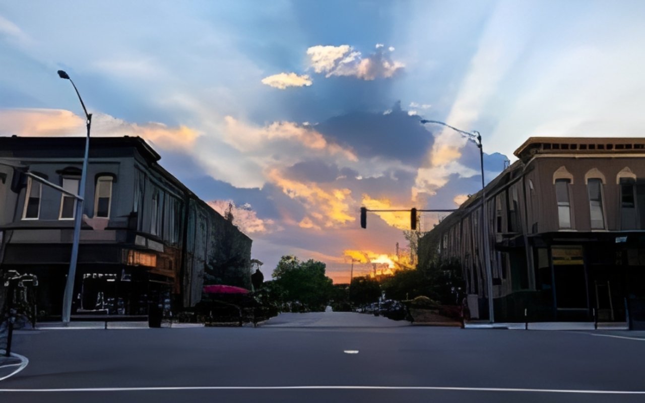 Downtown Goshen storefronts beneath dramatic sunset clouds.