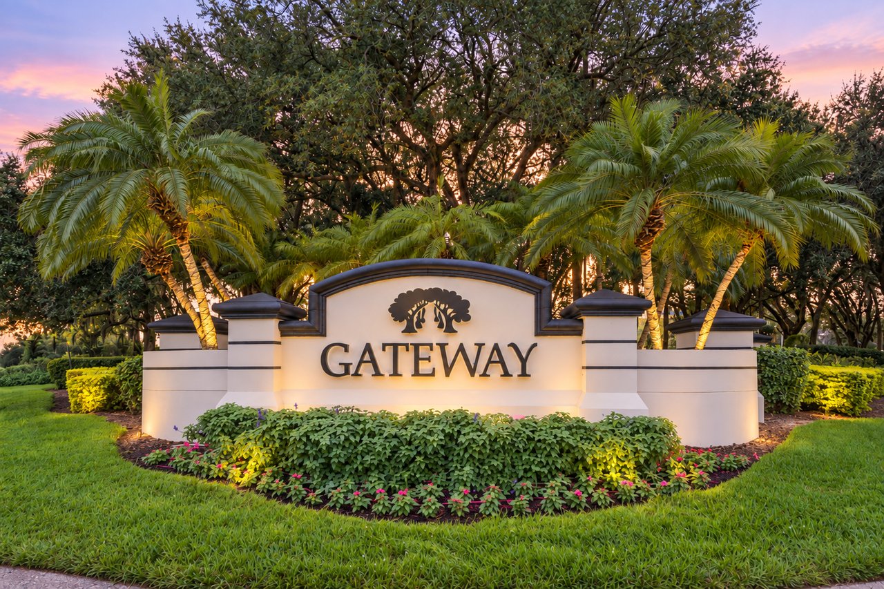 Gateway community entrance sign framed by palms at dusk.