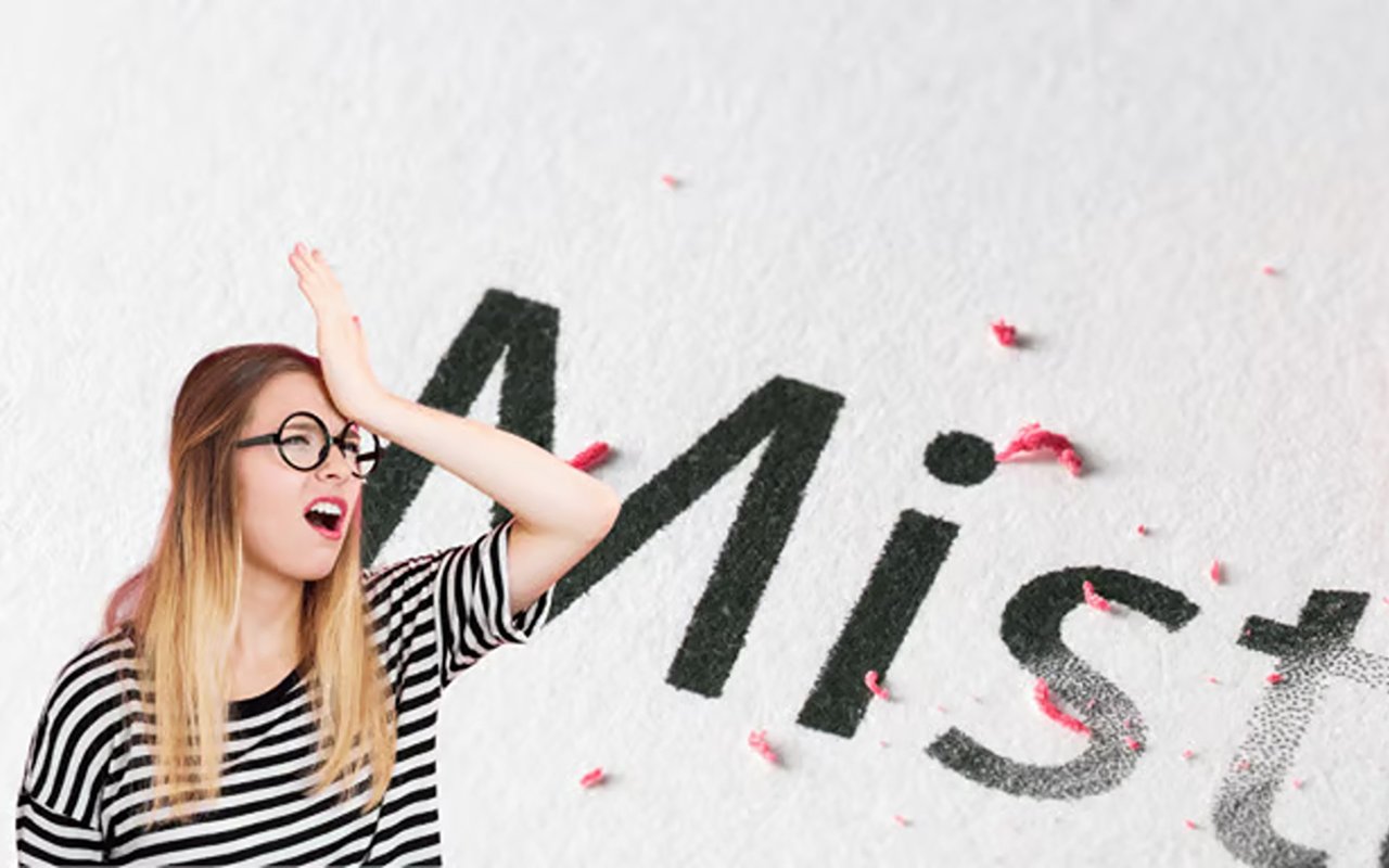 Frustrated woman in glasses raises a hand to her forehead beside the word “Mist.”