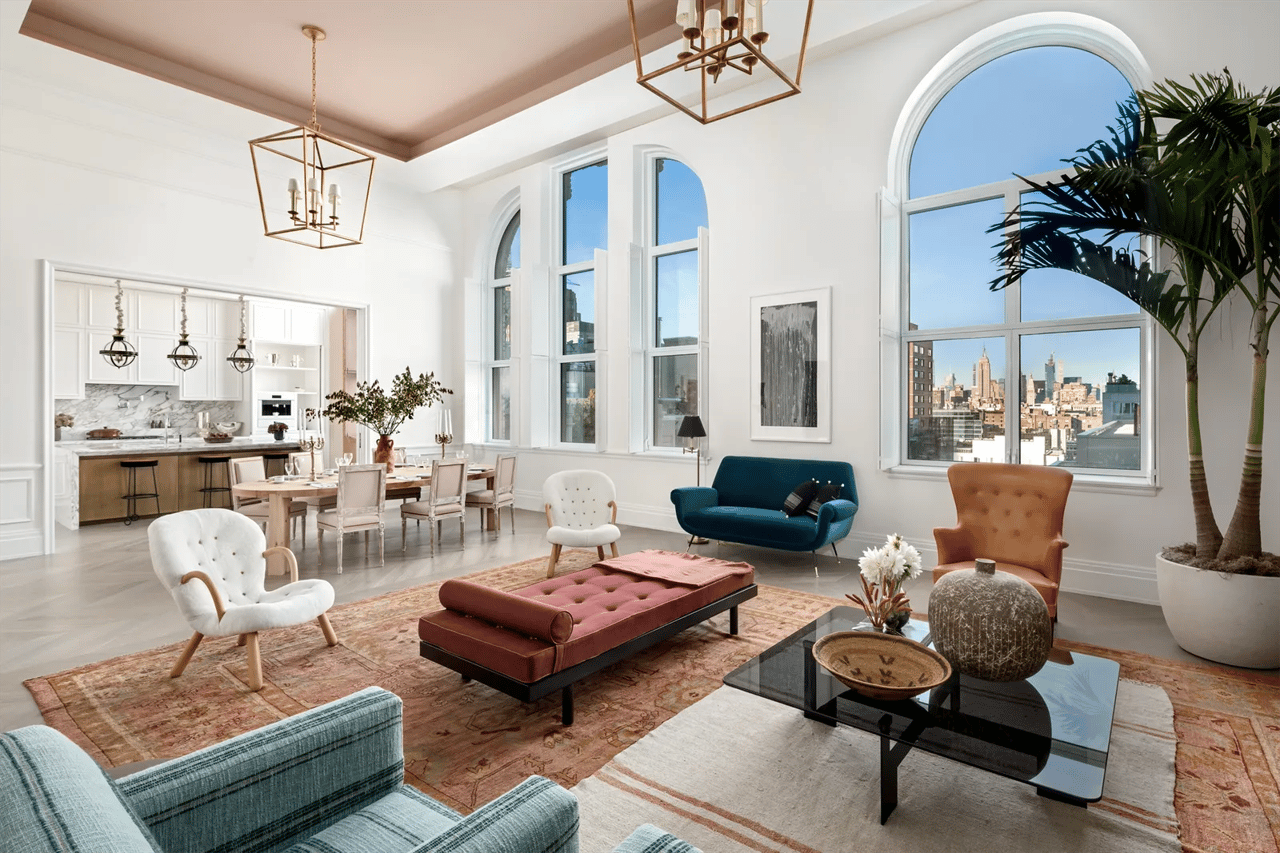 Living room with tall arched windows, contemporary furnishings, and a Manhattan skyline view.