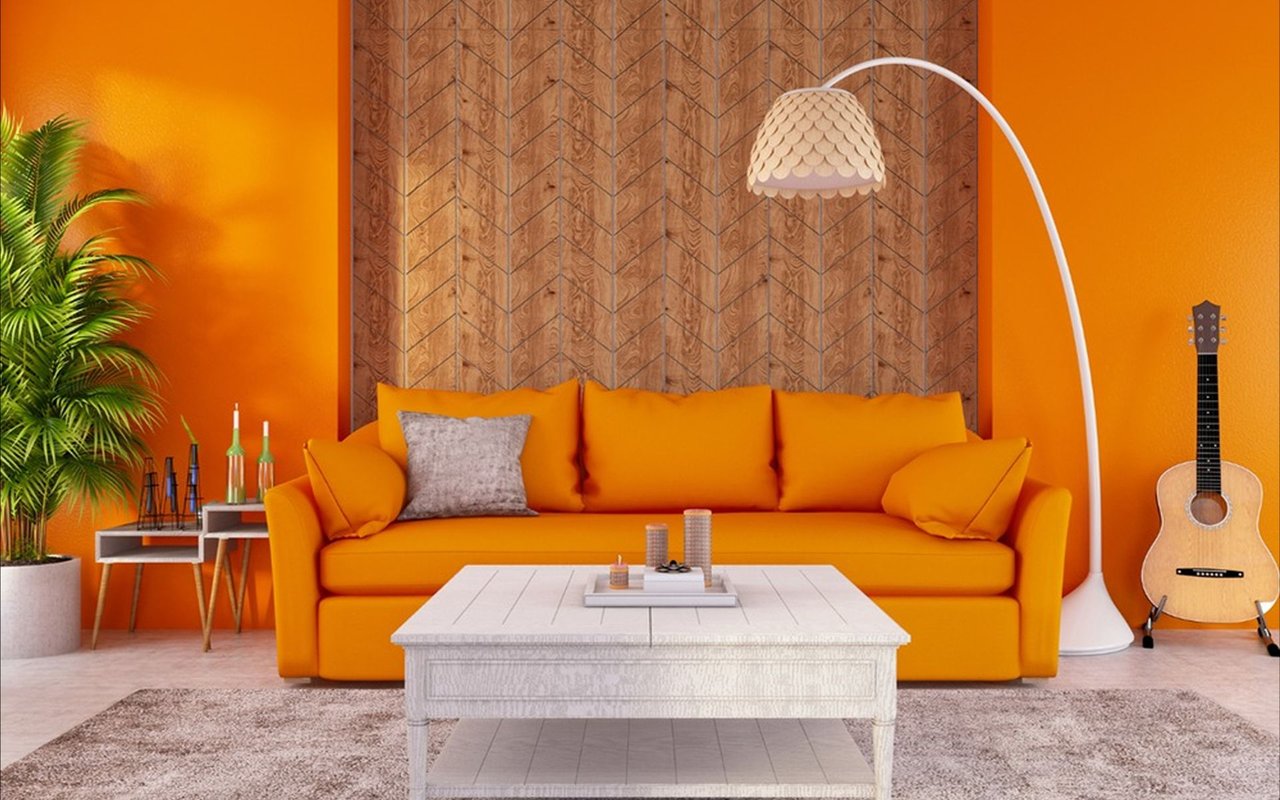 Living room with an orange sofa, patterned wood accent wall, white coffee table, and arched floor lamp.