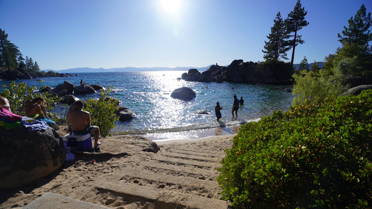 View of Incline Village’s private beach with crystal-clear Lake Tahoe water and pine trees