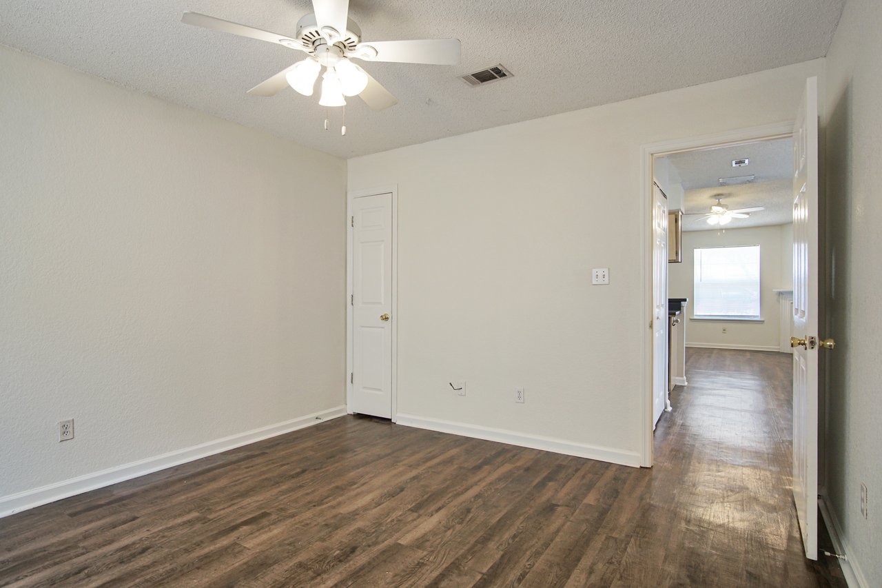 Empty room featuring hardwood floors and a ceiling fan, creating a spacious and airy atmosphere.Empty room featuring hardwood floors and a ceiling fan, creating a spacious and airy atmosphere.