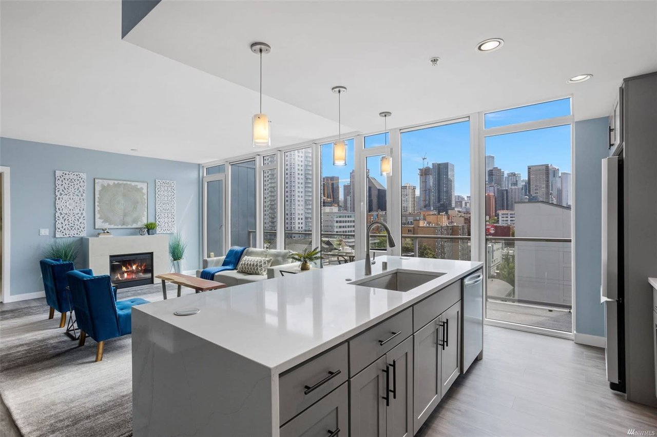 Luxury condo featuring a sleek kitchen, inviting living space, urban views, and modern design.