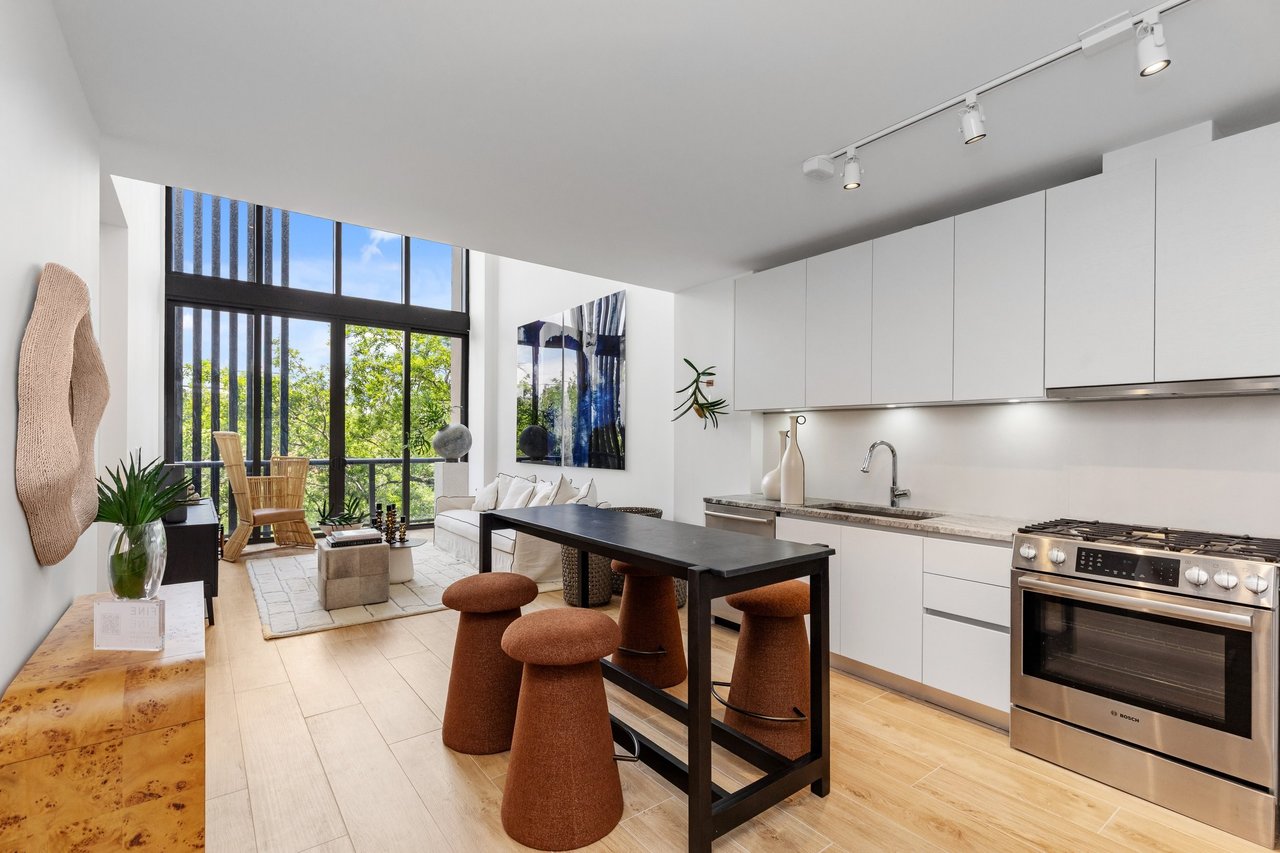 Arbor Coconut Grove residence kitchen with island seating and tall windows