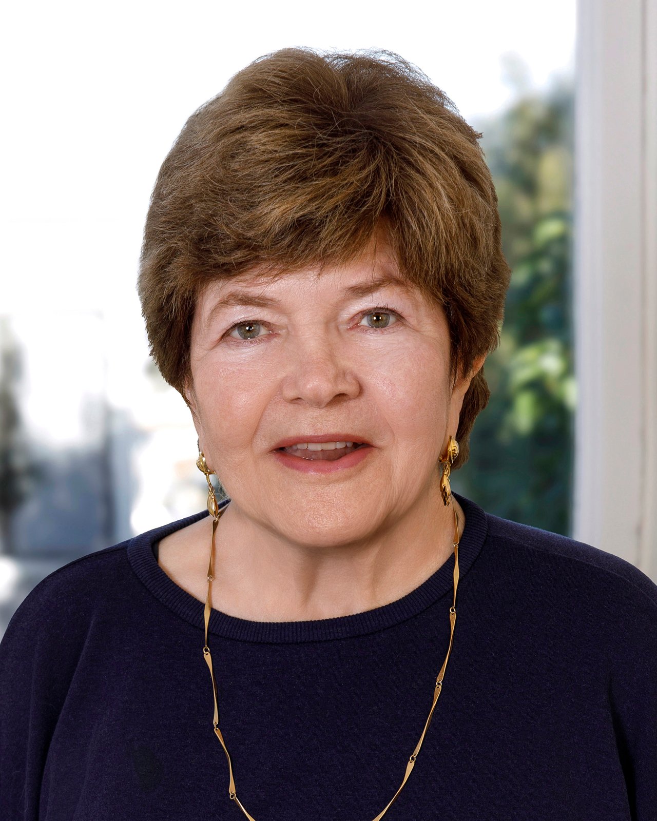 Carren Shagley, Founder / Associate Broker at Legacy Real Estate Headshot with gold earings and necklace.