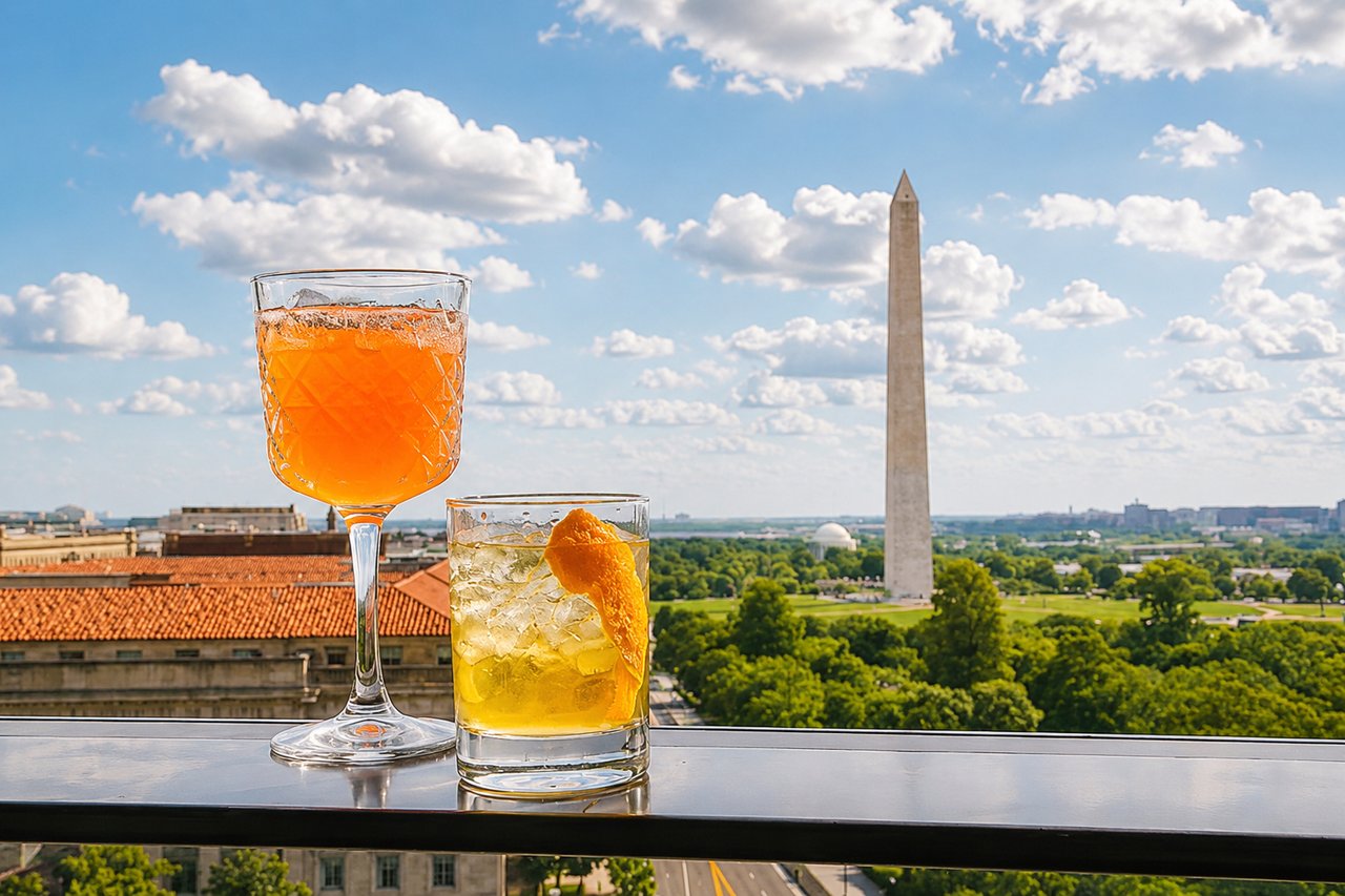 Cocktails on a Washington DC rooftop with the Washington Monument in the background on a summer afternoon