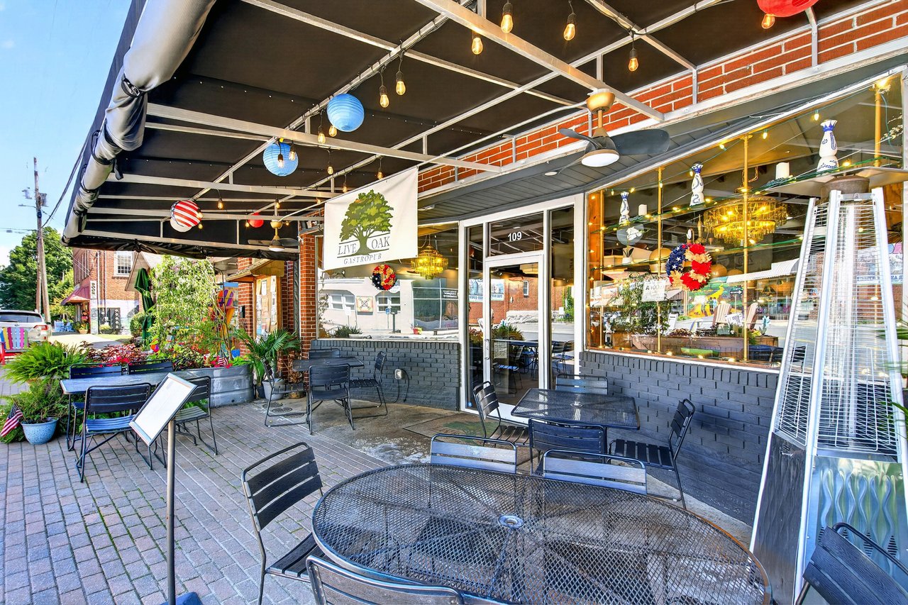 Live Oak Gastropub storefront with covered outdoor patio seating and a brick facade.