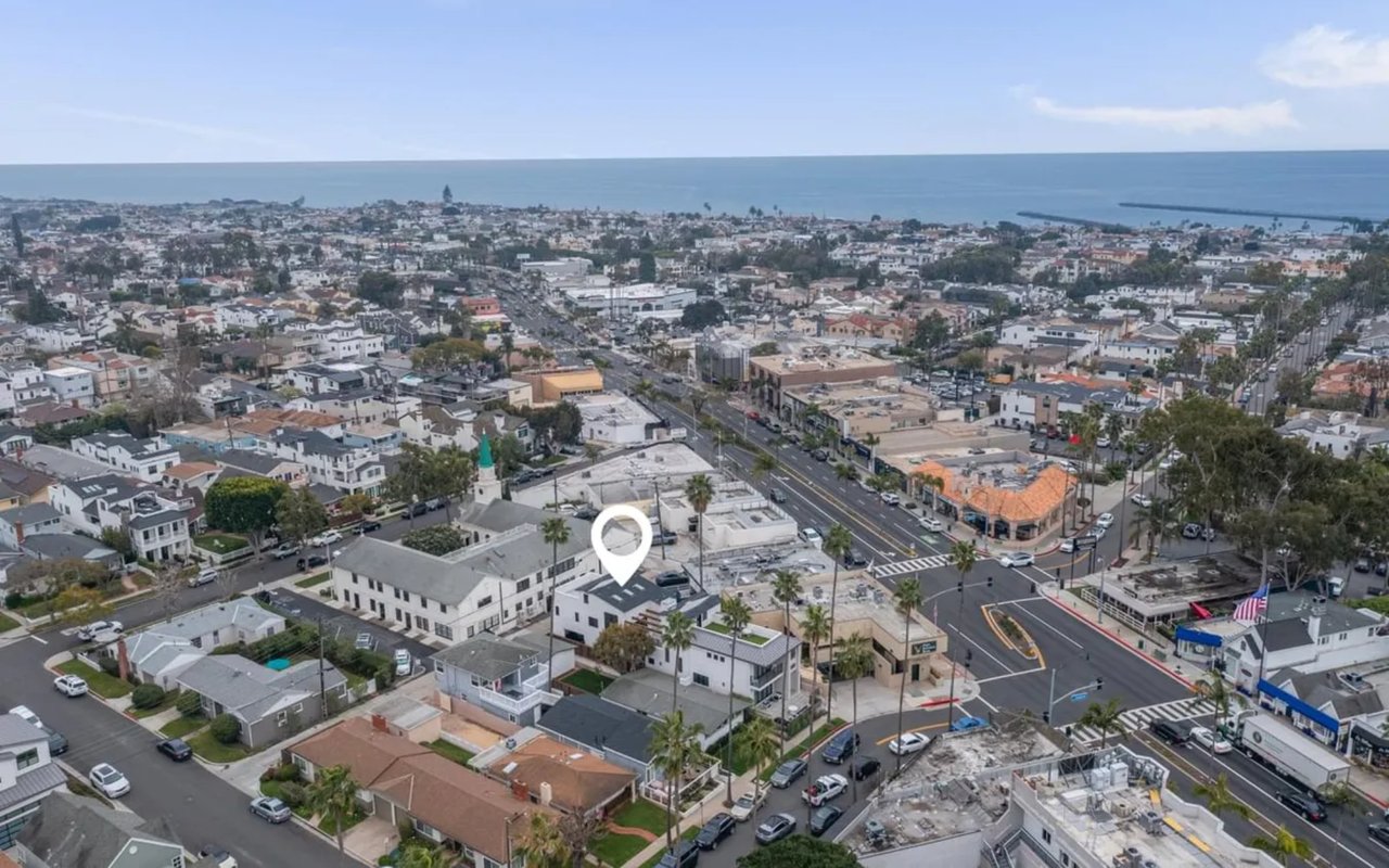 An aerial view of Corona del Mar, California, shows a neighborhood with homes and businesses leading to the Pacific Ocean.