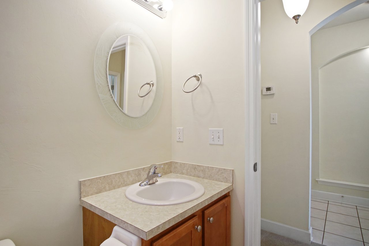 Bathroom at 5441 Hampton Hill Circle, Tallahassee, Florida 32311 featuring vanity with single sink, round mirror, and neutral finishes.