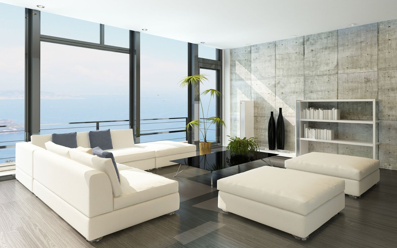 A bright and airy living room with a large window overlooking the ocean.