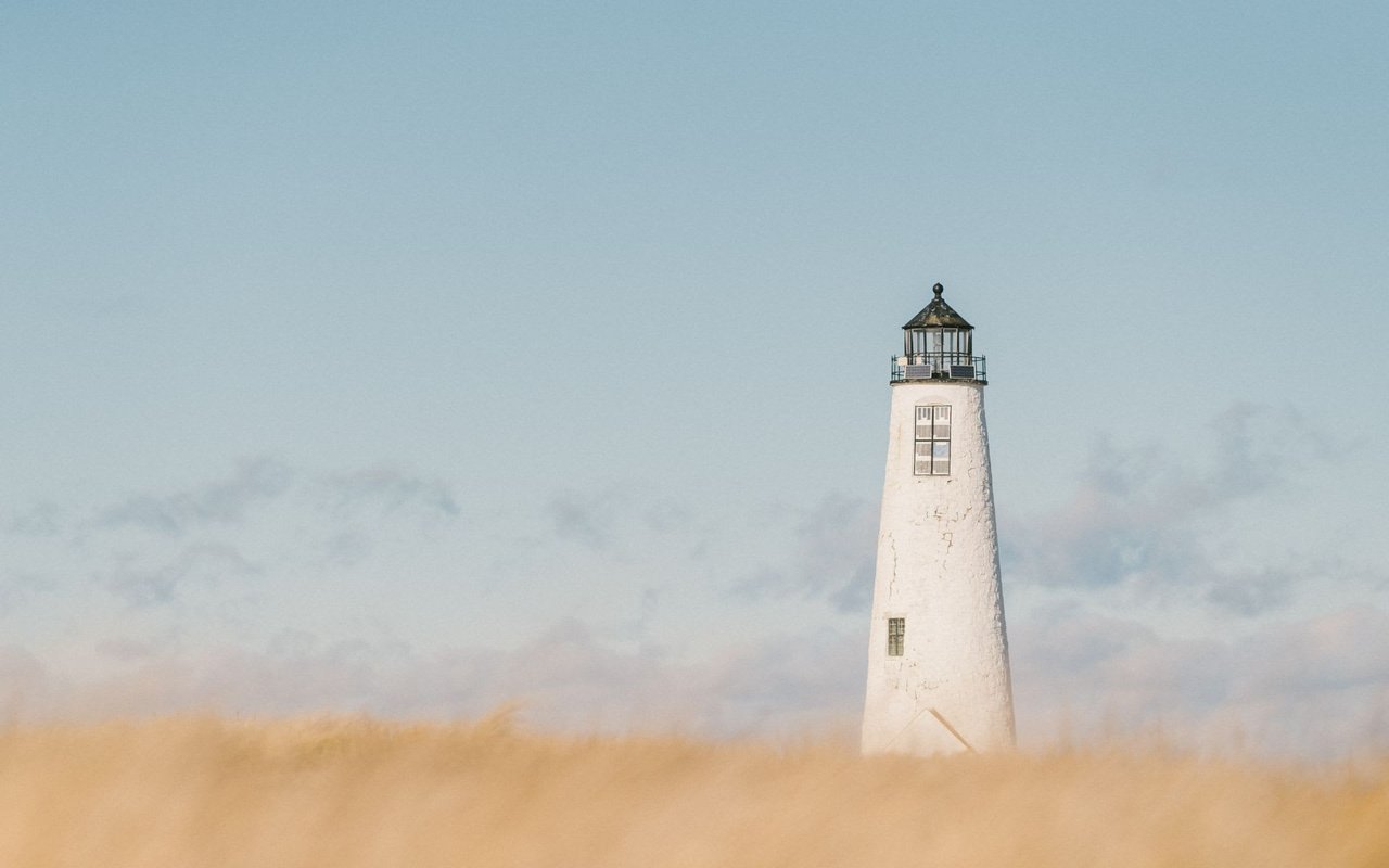 White lighthouse in a grassy field in Wauwinet.