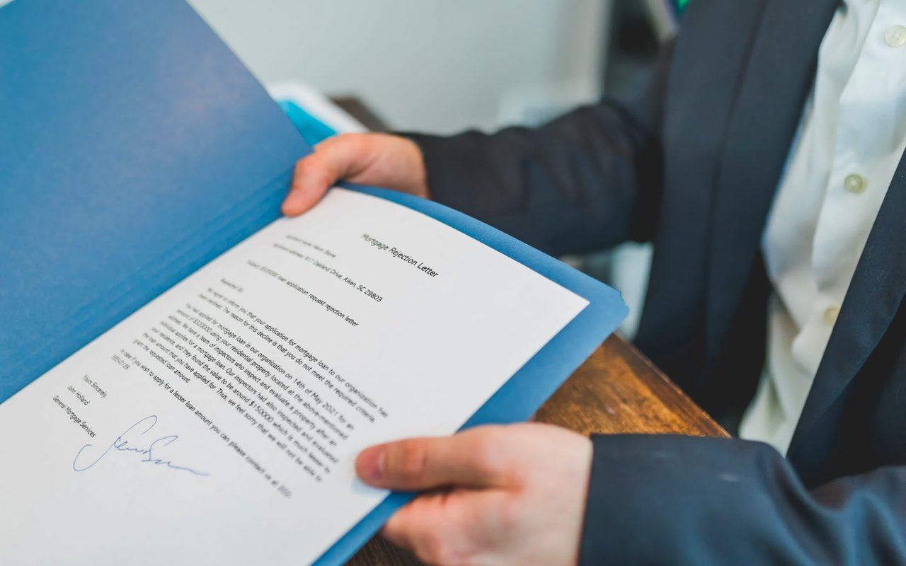 A professional man holding a document, indicating business success and effective communication.