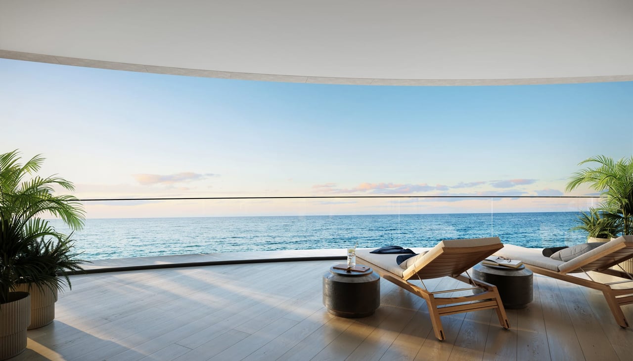 Oceanfront terrace with wooden lounge chairs, palm planters, and open water views.