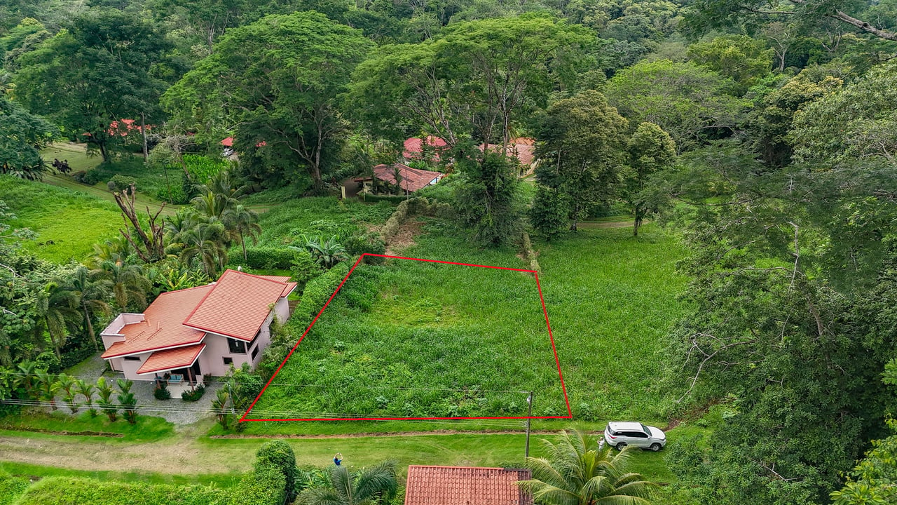 A beautiful sunny lot in a secure gated community with a nearby creek and jungle-covered valley.