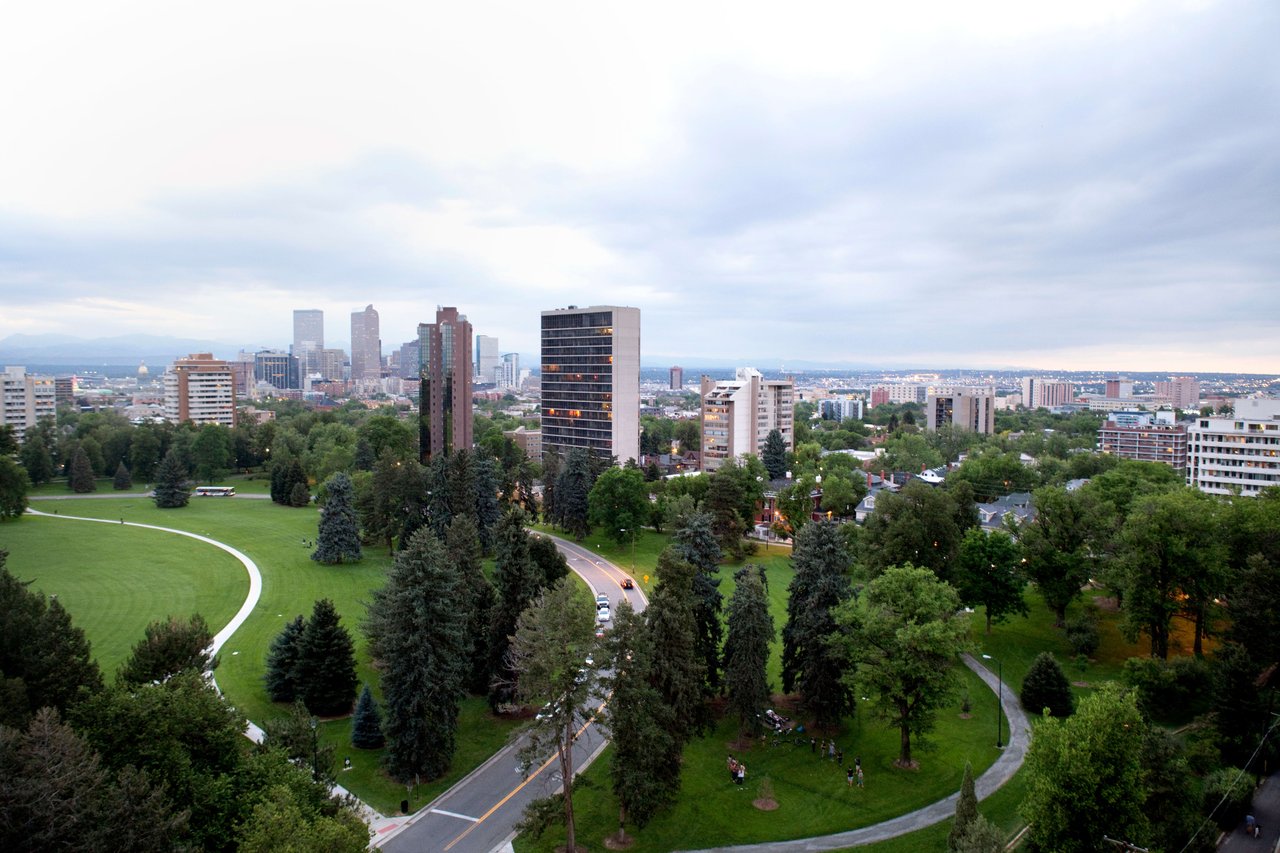  An expansive aerial view of a city park with winding pathways and numerous trees