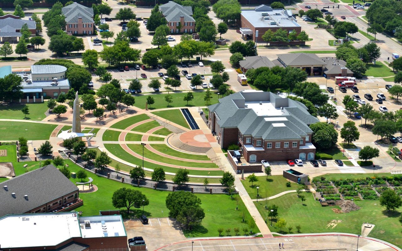 An aerial view of diverse residence halls, notable buildings, athletic facilities, trees, and an open green space.