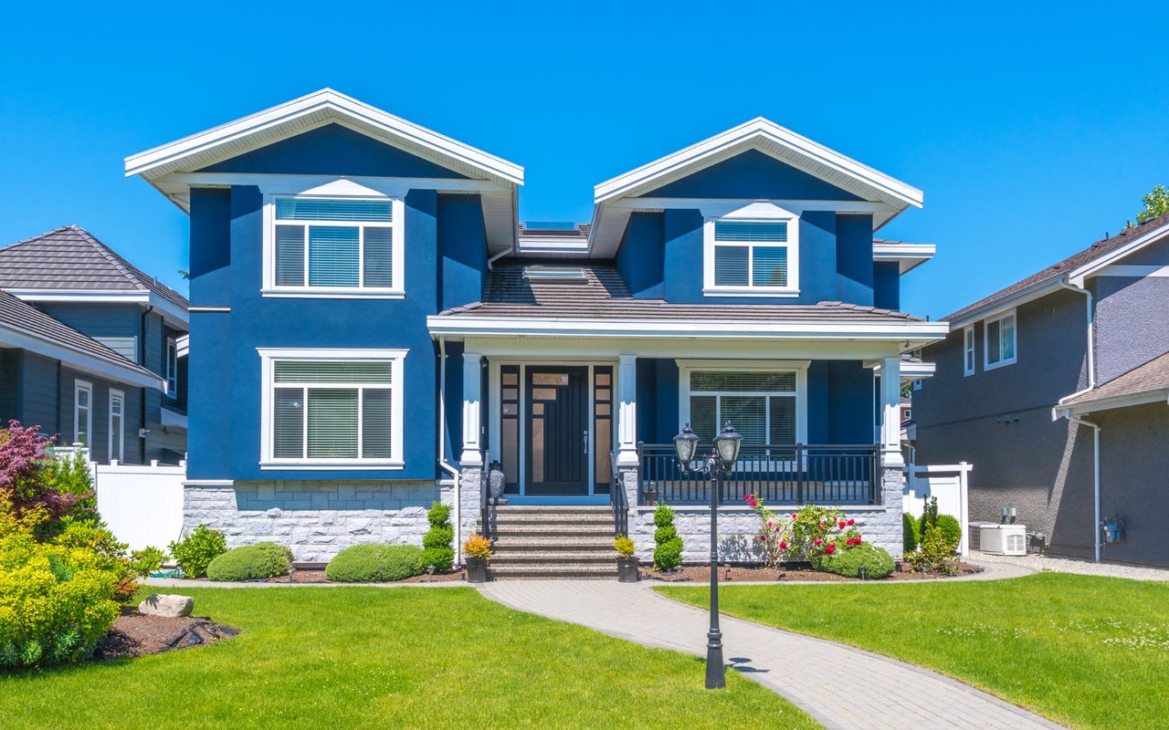 A blue house with white trim in a quiet residential neighborhood.