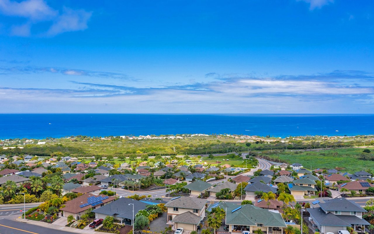 An aerial view of a residential neighborhood in Kona Vistas with a beautiful ocean view