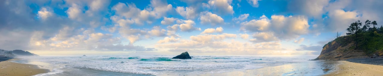 Arch Cape's Murfey rock with puffy clouds