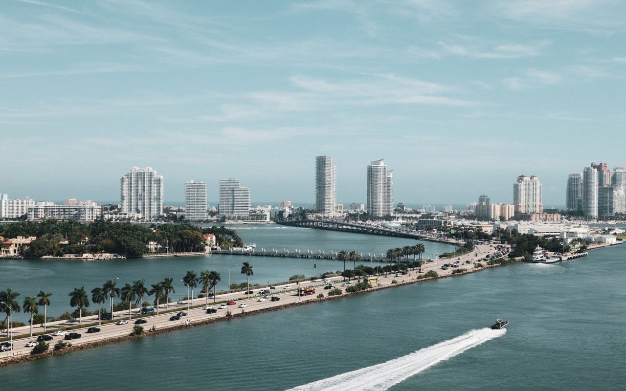 A view of Downtown city from across the water, with a boat sailing in the foreground