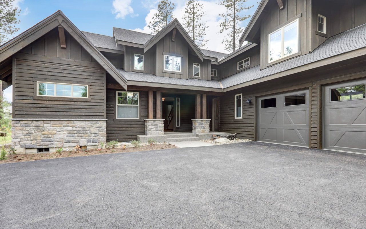 Modern two-story house, with diverse windows for light/views, flat roof, and varied exterior materials: wood, stone, glass.