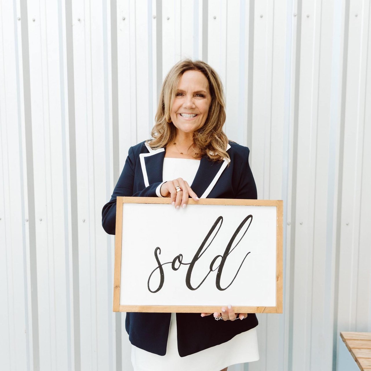 Michele Colombo holding a sold sign, Roseville real estate agent offering free home valuations
