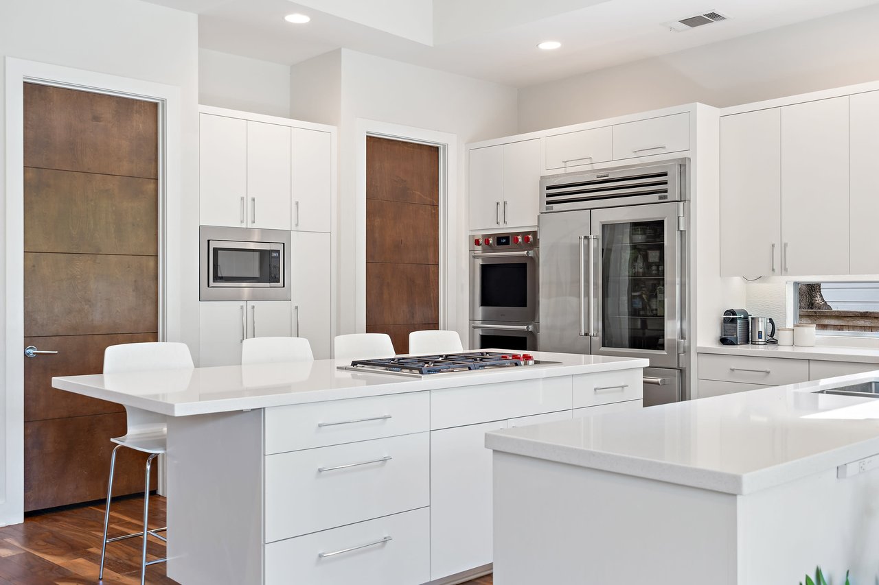Chef's kitchen at 34 Margranita Crescent, Tarrytown, Austin, TX, with a quartz island, stainless steel appliances, and a Sub-Zero refrigerator.