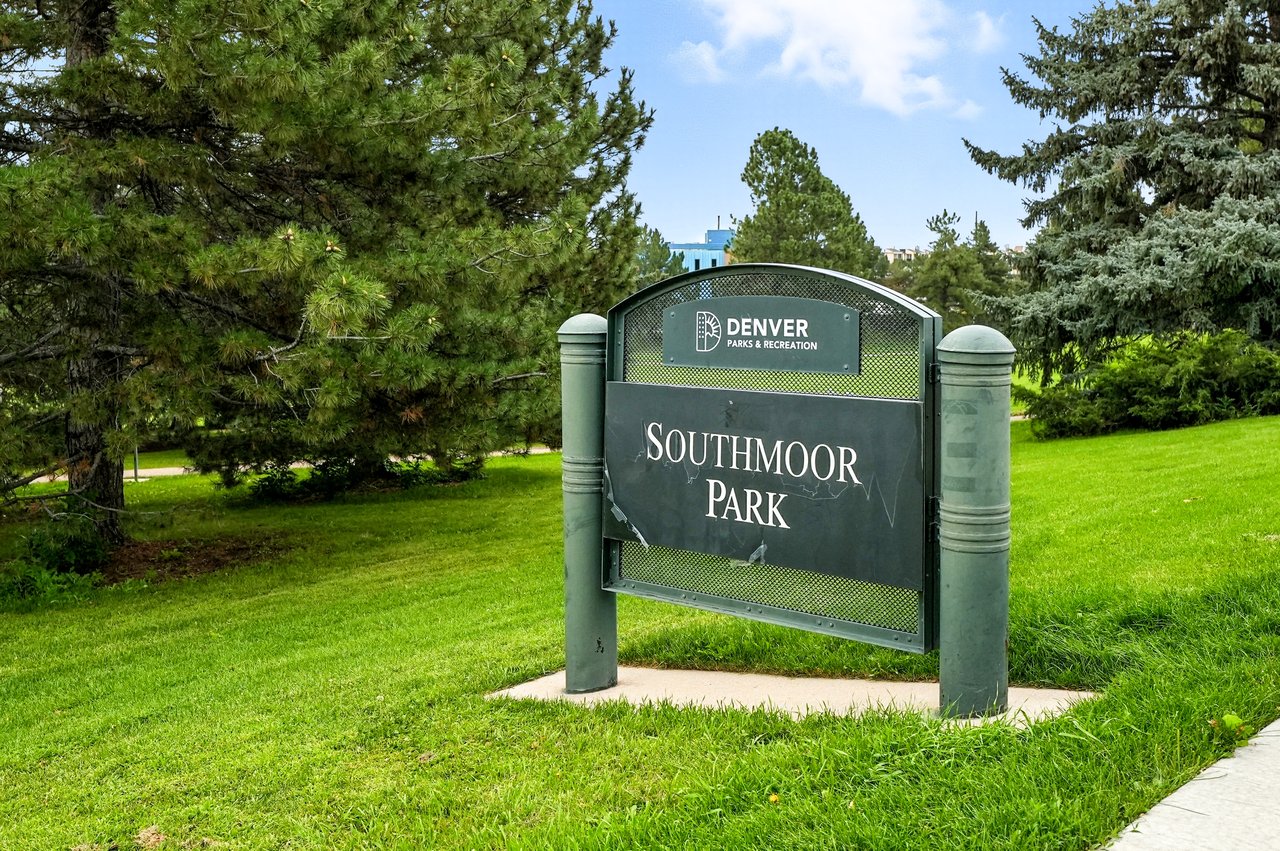 Entrance sign to Southmoor Park in Denver, CO with landscaped green space and trees.