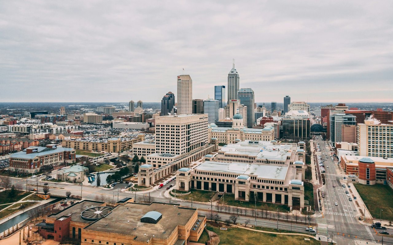 Aerial view of downtown Indianapolis with Salesforce Tower rising above the surrounding buildings.