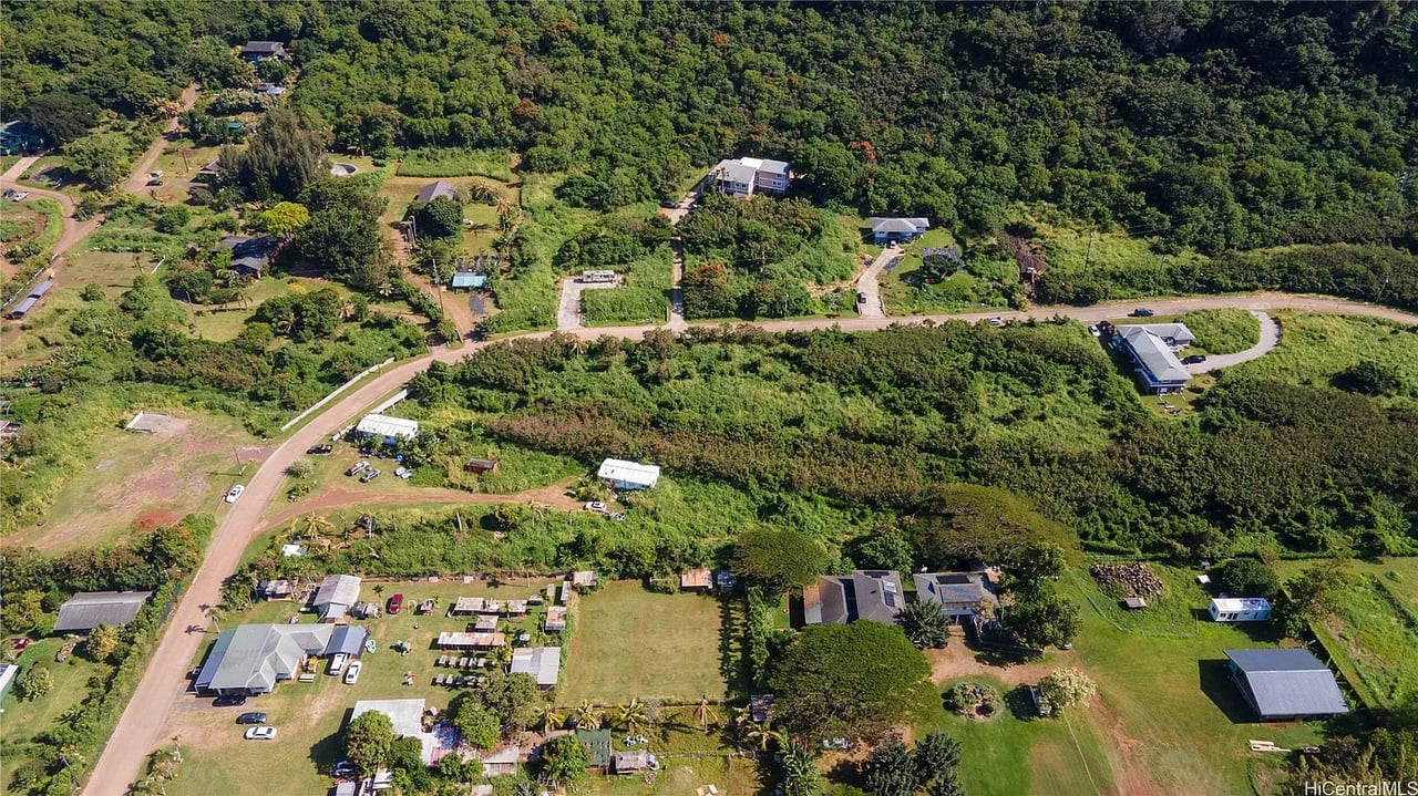 Aerial view of the 59 Kekiliohulani St area, with scattered homes, winding roads, and dense green forest.