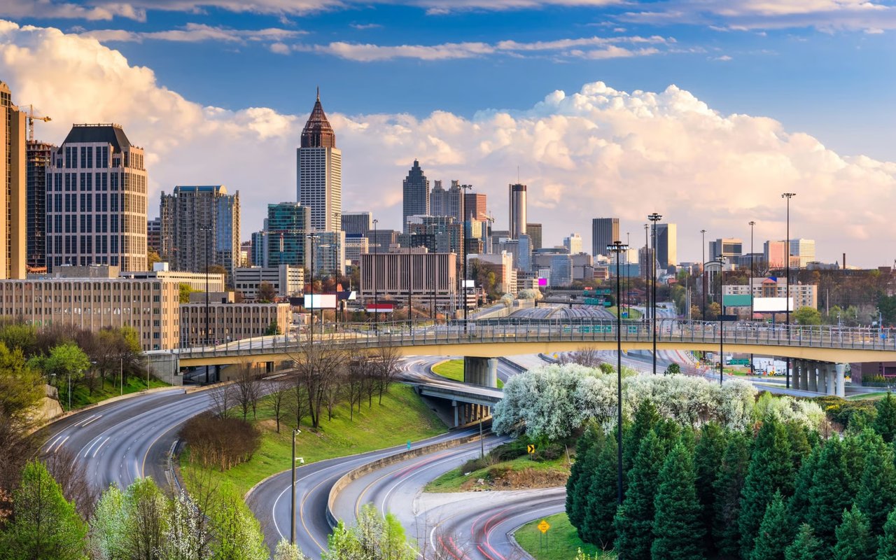 Atlanta skyline above a curving highway interchange and elevated bridge.