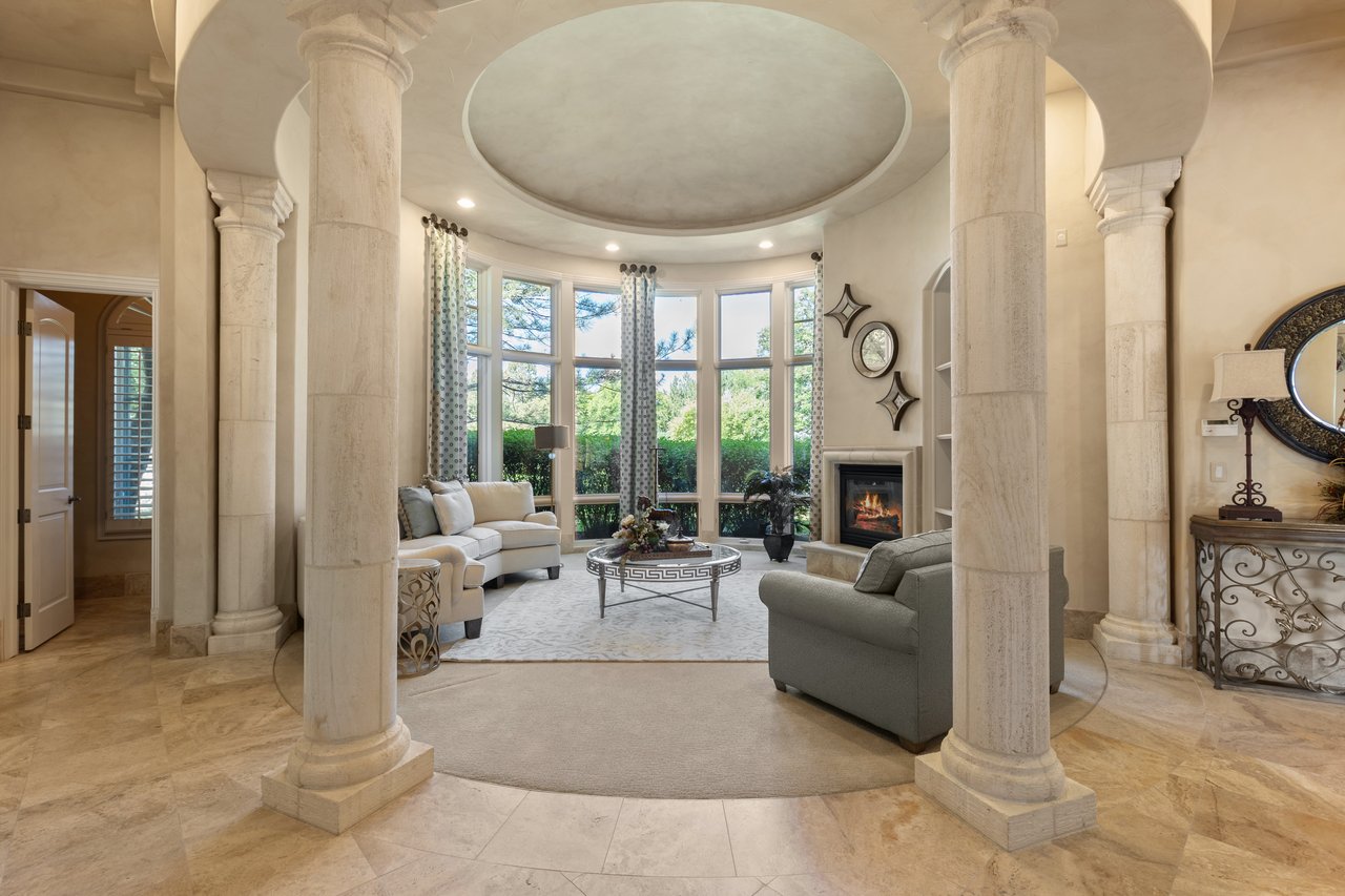 Guest house living room with stone columns, curved windows, and a fireplace
