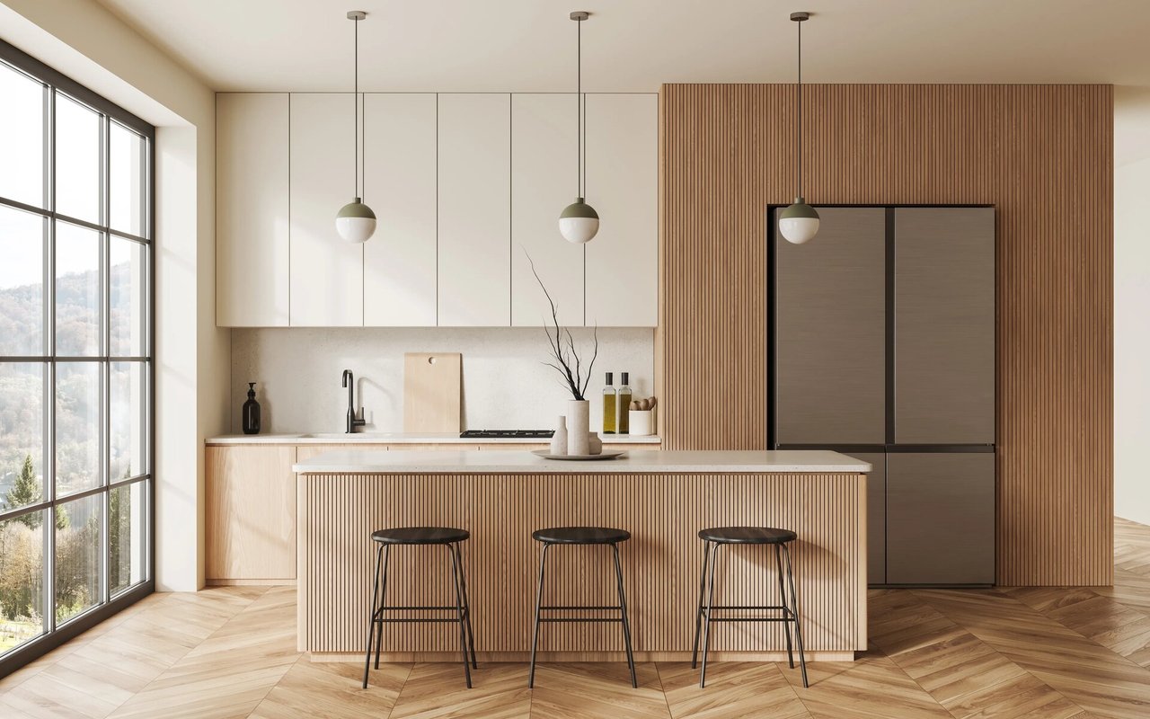 Modern kitchen with a wood-slat island, three bar stools, and mountain views through a large window.