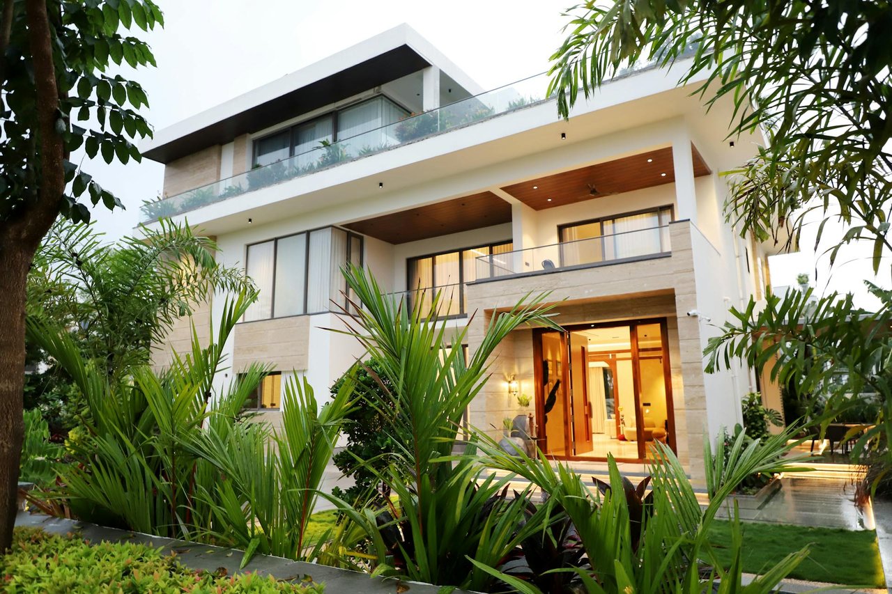 Modern luxury villa with tropical landscaping, open balconies, and contemporary architectural design