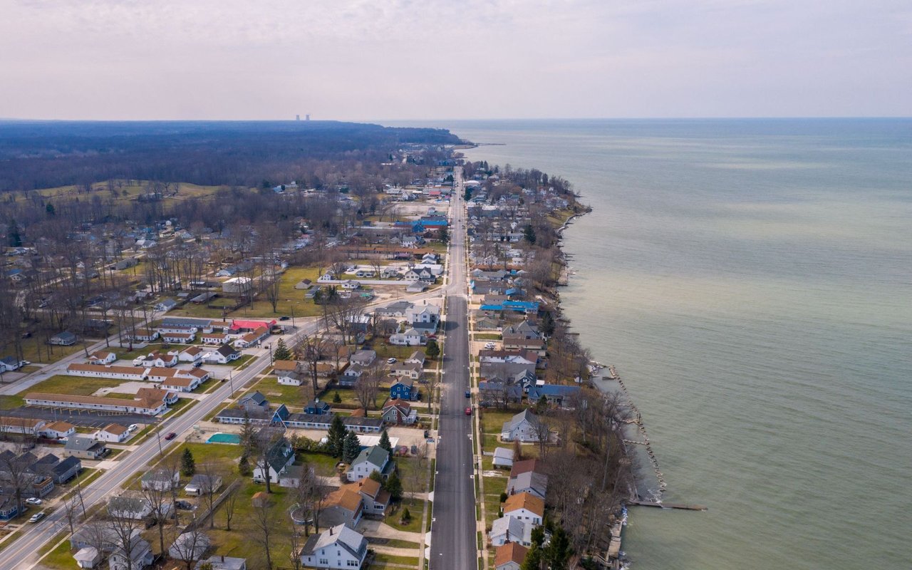 Aerial view of a lakeside neighborhood with homes along the shore.