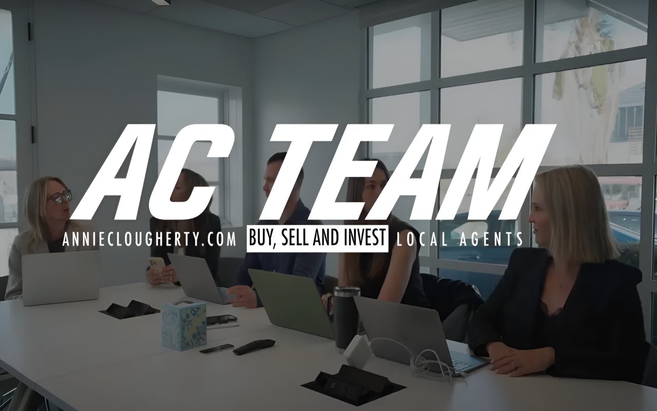  A diverse team of professionals sits around a conference table with laptops, with a large "AC TEAM" logo superimposed.