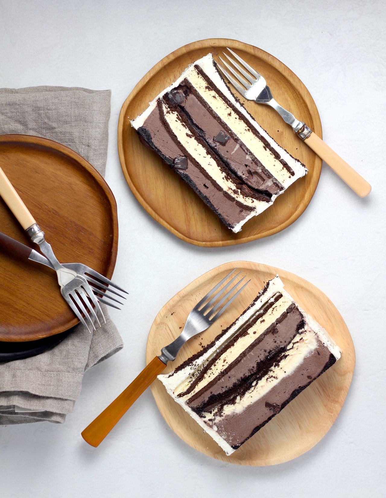 Layered ice cream cake with ladyfinger crust and glossy chocolate topping.