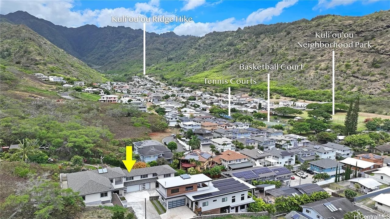 Aerial view of 466 Lani St, marked by a yellow arrow below a green mountain valley.
