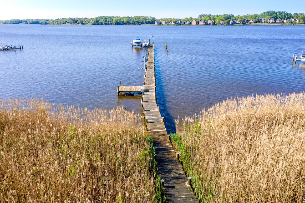 A marsh and framites looking out to a pier and boat lift on the Chesapeake