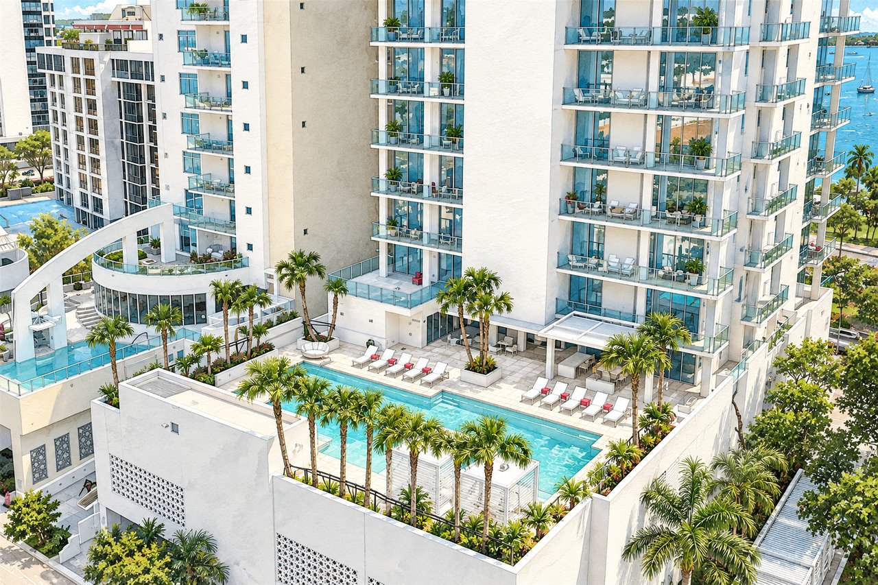 Modern white condominium tower with glass balconies overlooking a palm-lined swimming pool and waterfront.