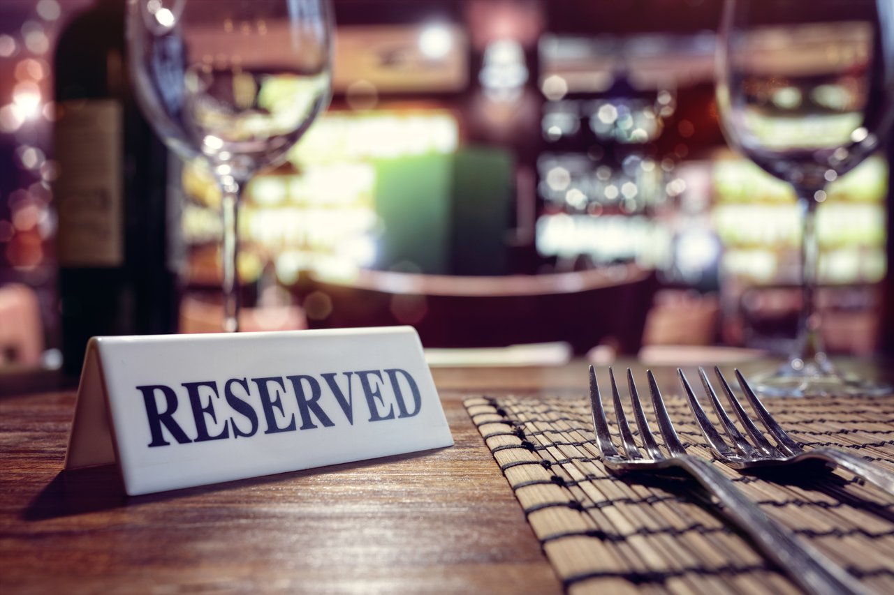 RESERVED sign sits on top of a formally set table at a restaurant