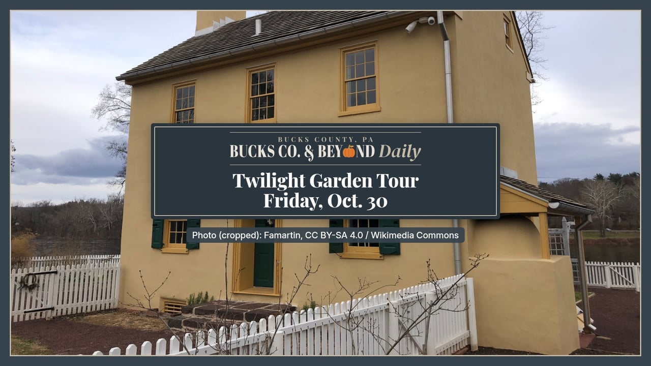 The yellow two-story Hibbs House with green shutters behind a white picket fence and its kitchen garden beds in Washington Crossing Historic Park.