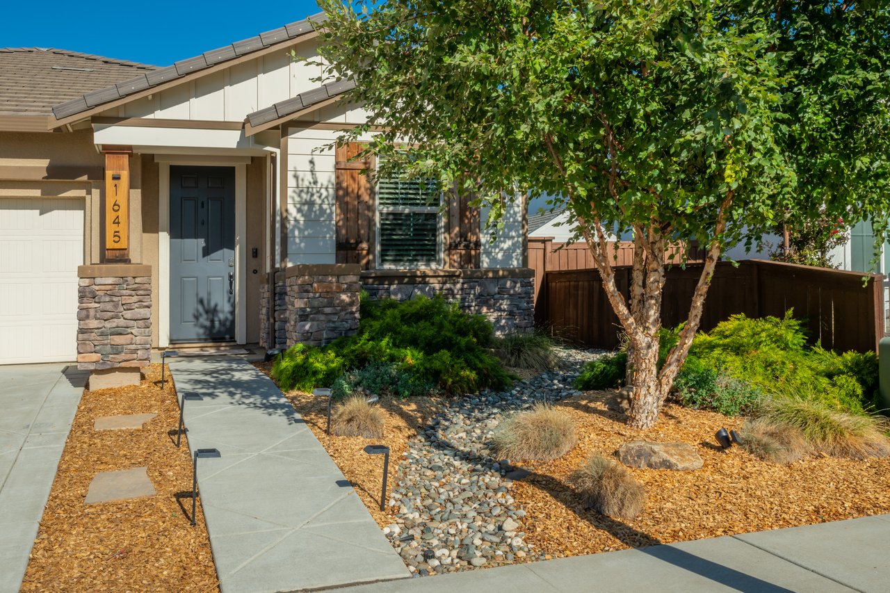 Home exterior with stone accents, a landscaped rock garden, and address number 1645.