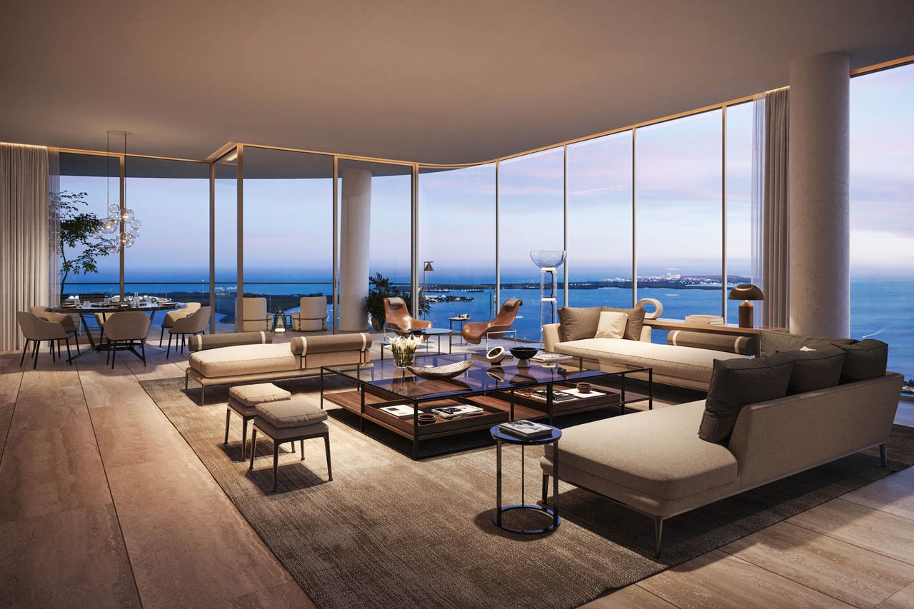 Staged living room with floor-to-ceiling windows overlooking Biscayne Bay and the Miami skyline.