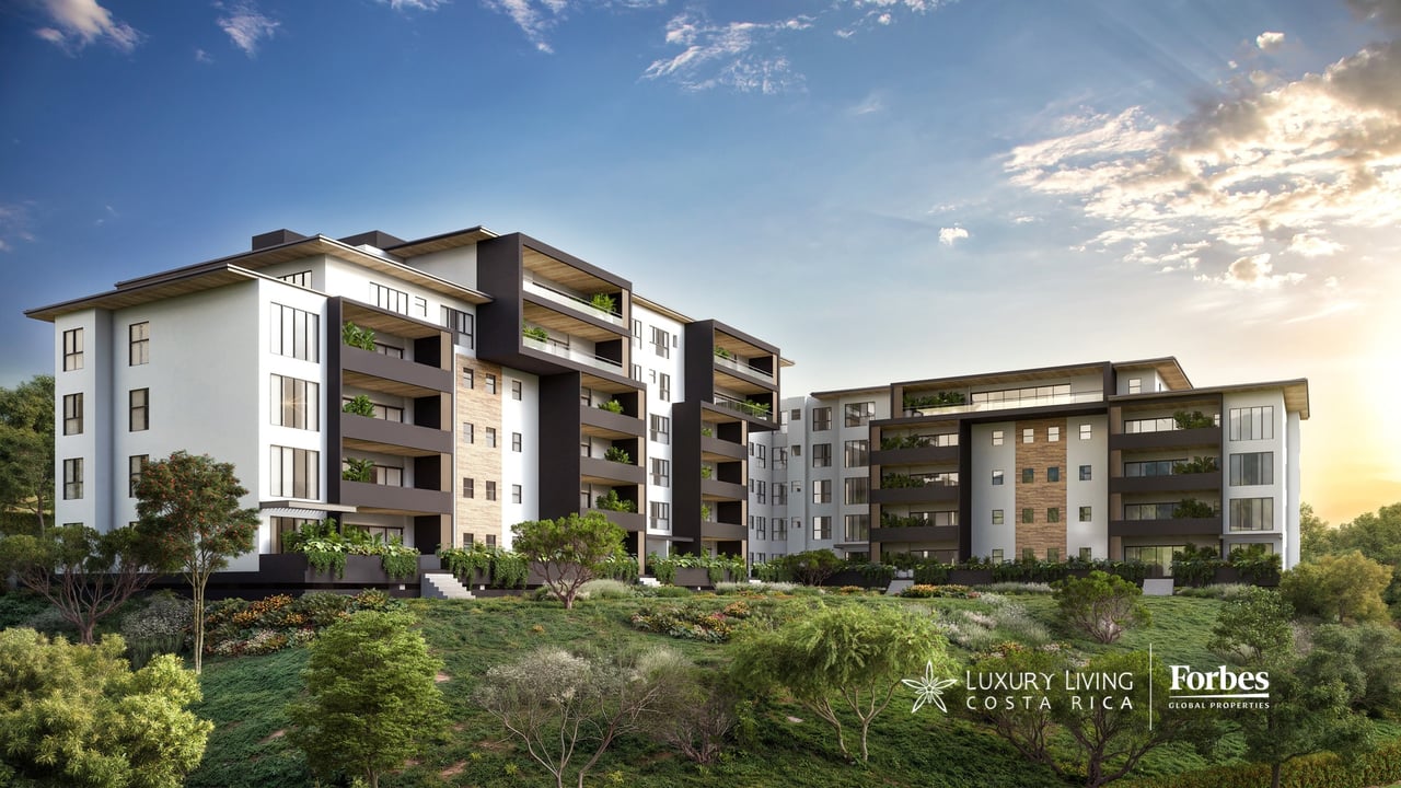 Modern apartment buildings with planted balconies and landscaped gardens at sunset.