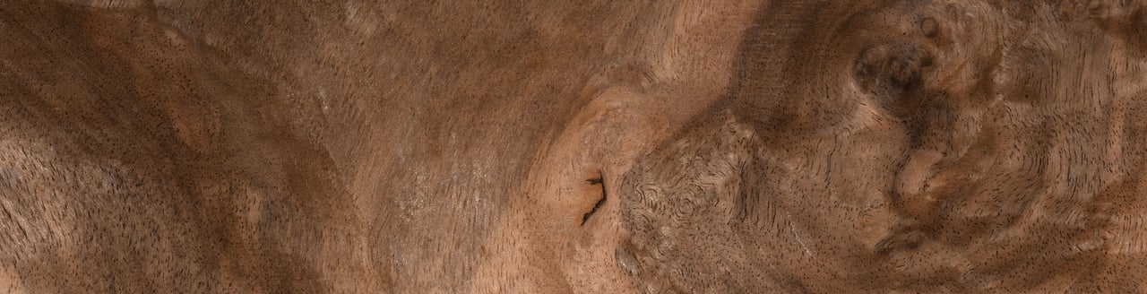 Reddish-brown natural surface with speckled, swirling grain-like patterns.