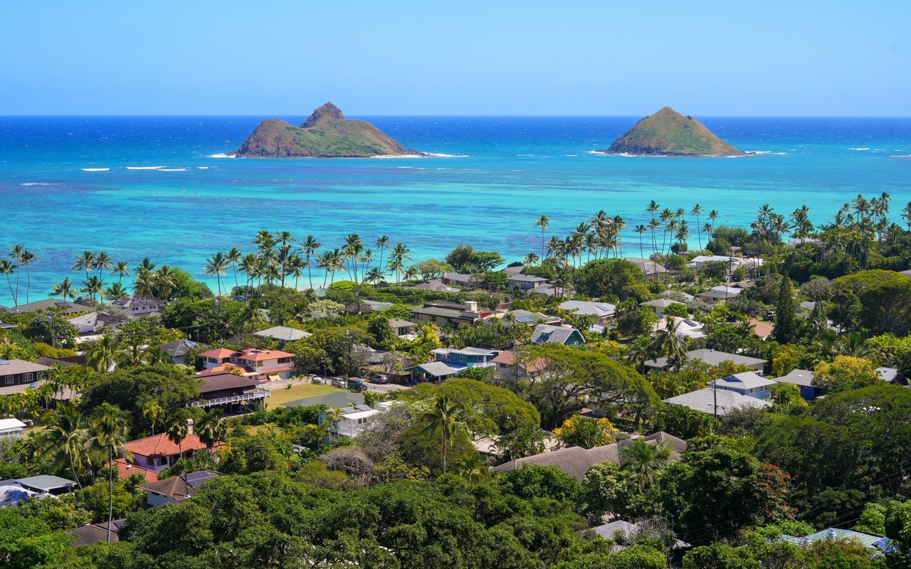 Kailua coastal neighborhood with palm-lined homes, turquoise water, and the Mokulua Islands offshore.
