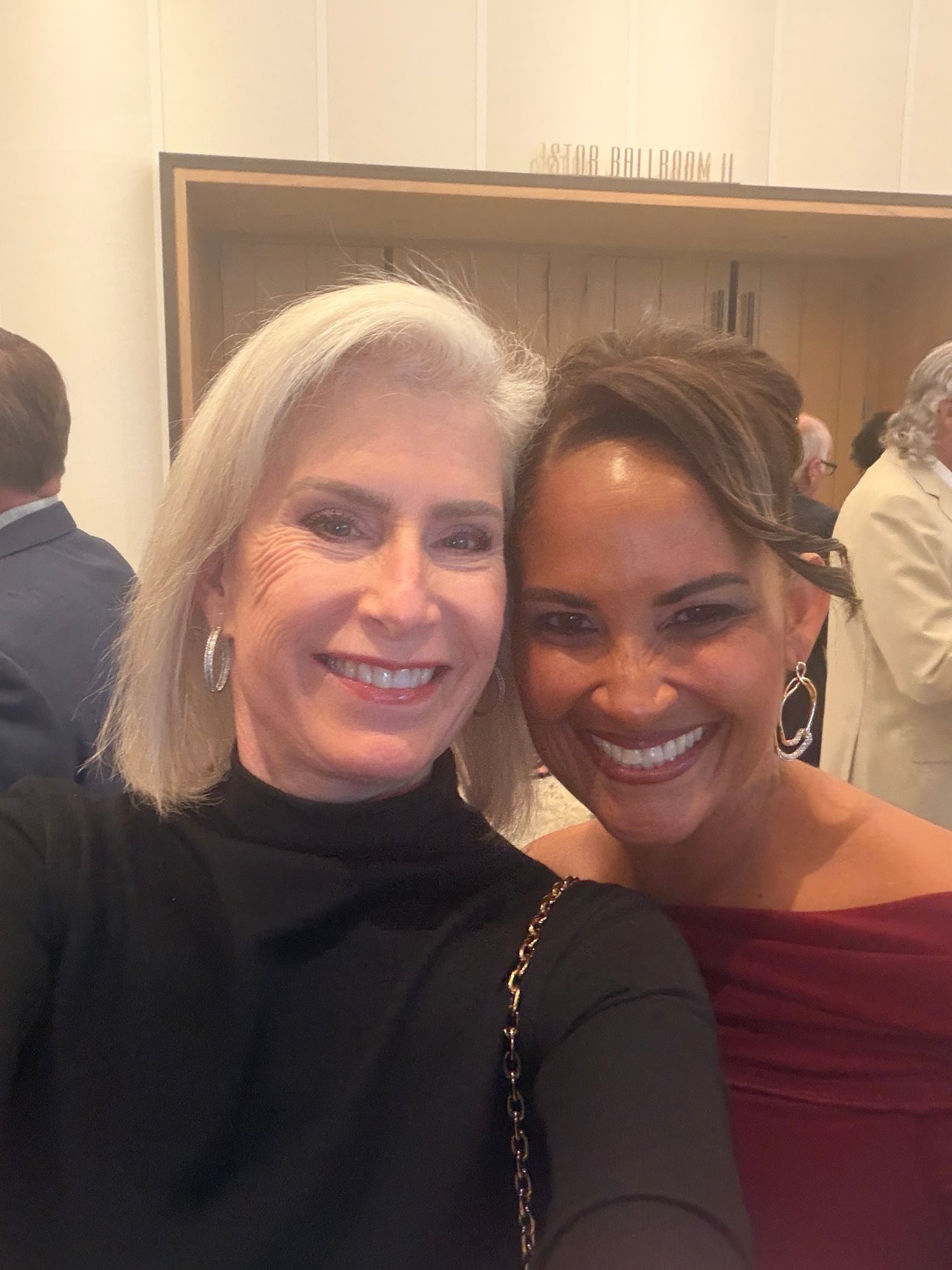 Two women smile for a selfie at an awards event.
